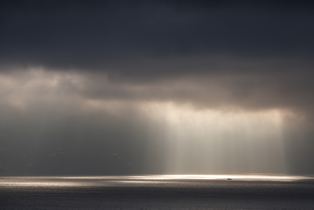 Bright sunlight goes through dark stormy clouds