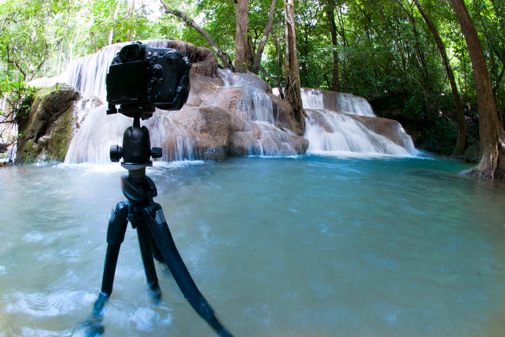 camera on tripod taking pictures of a waterfall