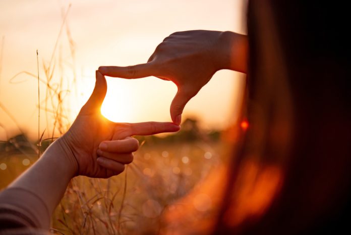 Close up of woman hands making frame at sunset
