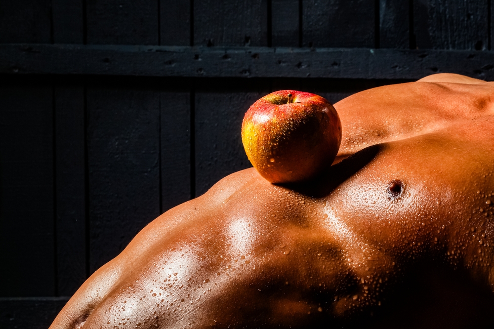 male torso with an apple and beads of water