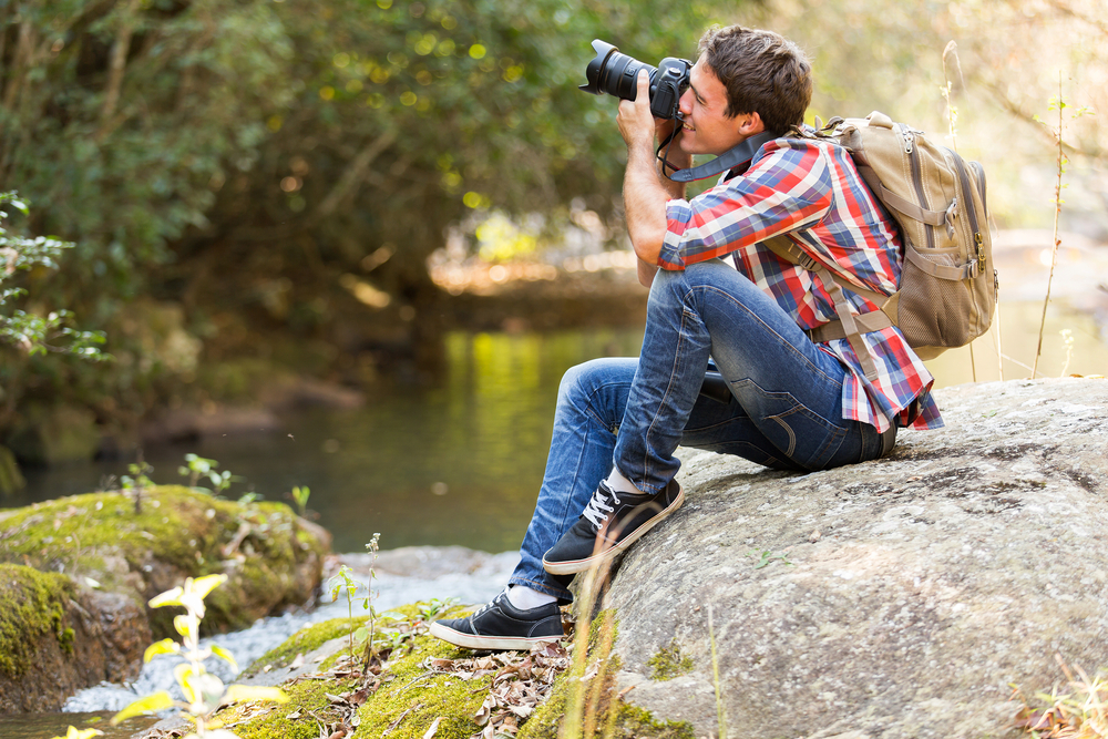 Nature Photographer using his knee and elbow to stabilize his camera