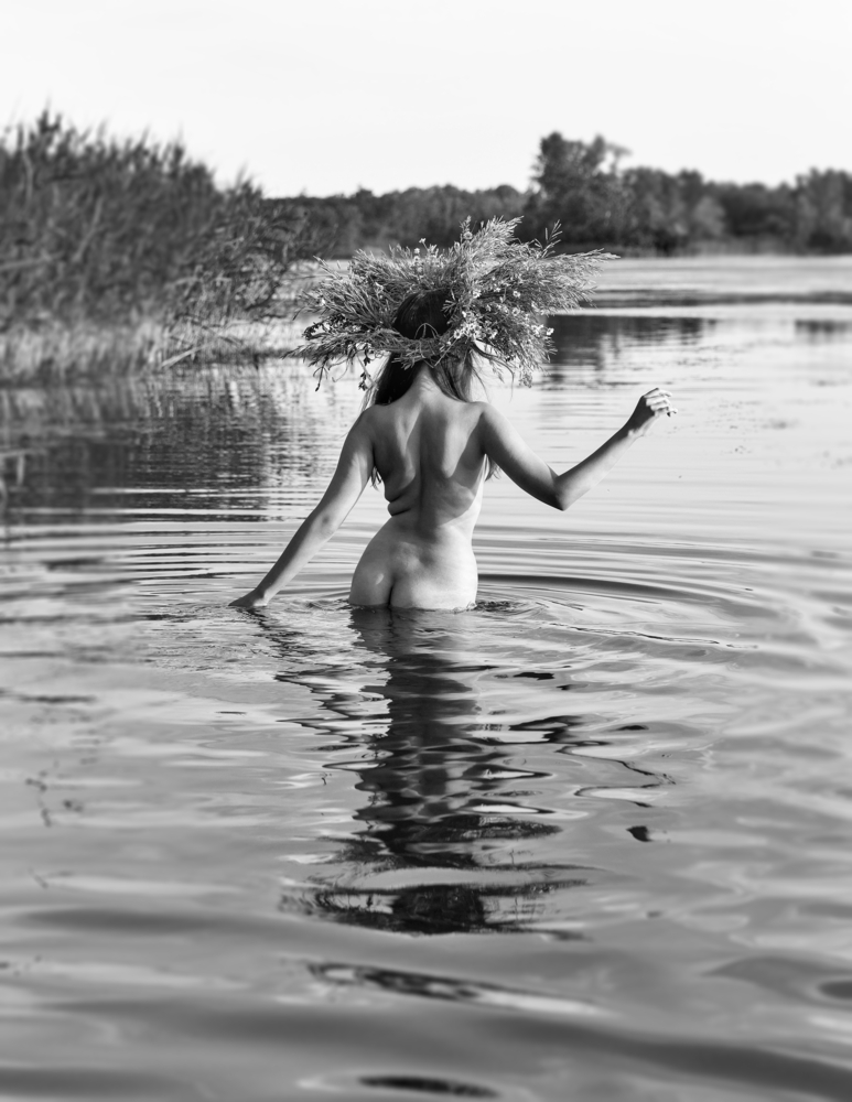 nude woman with wreath of flowers oh her head in the water