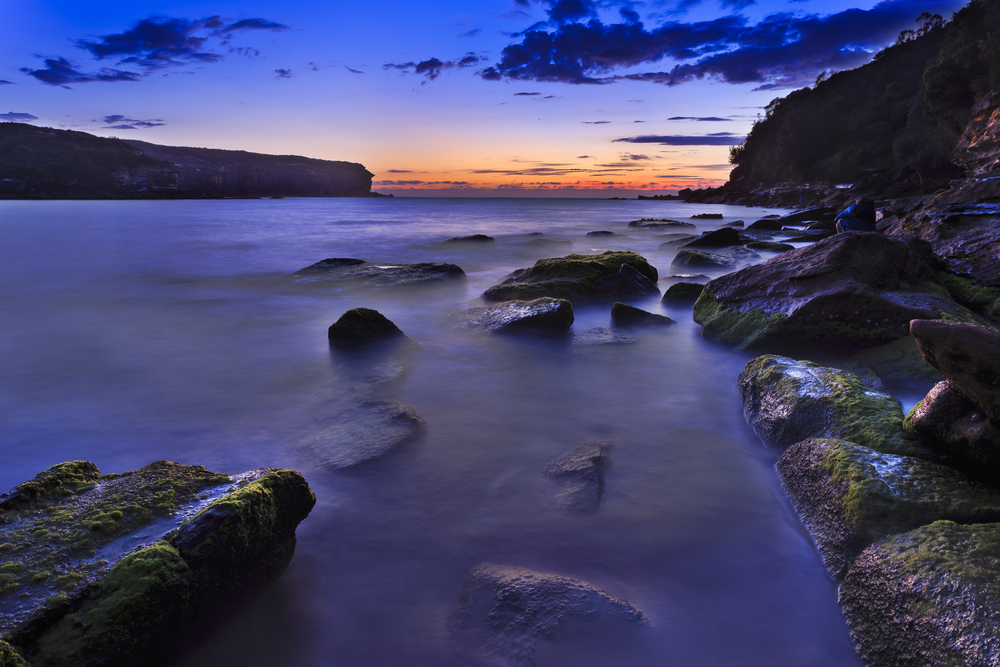 rocky beach in lagoon sunrise during blue hour