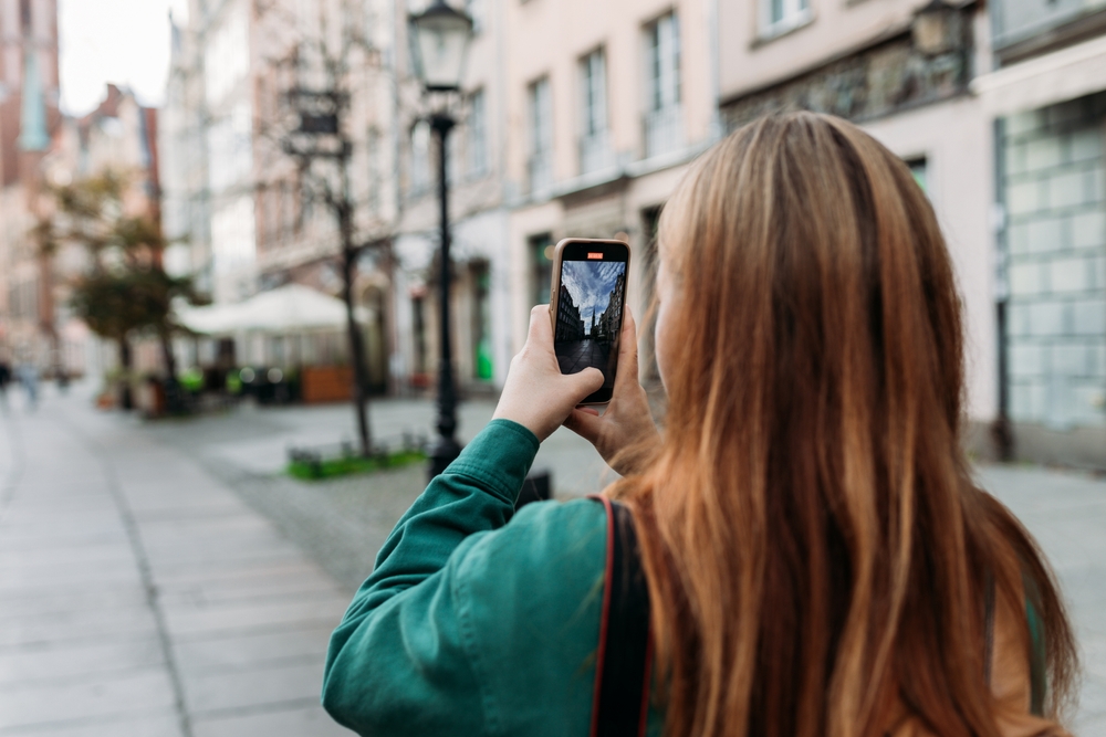 woman taking photos with her phone in the city